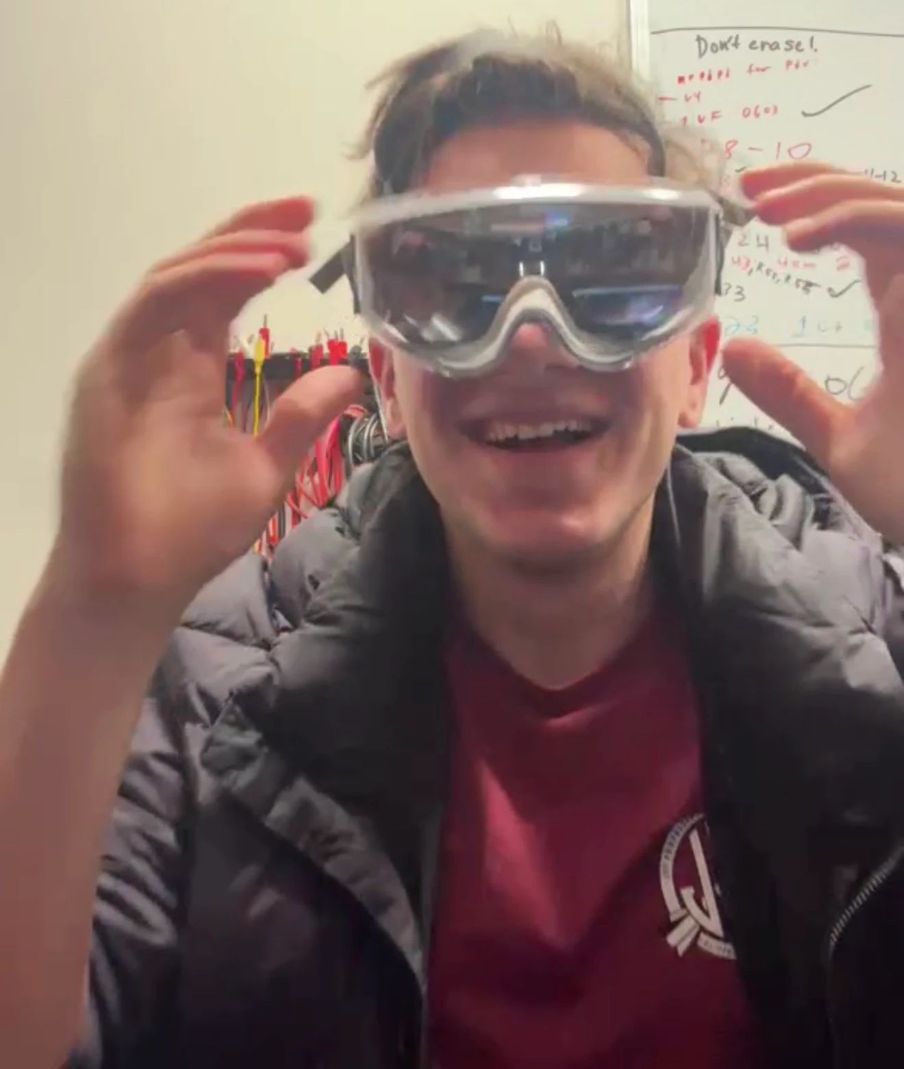 Rob grinning while holding a pair of goggles up to his face.